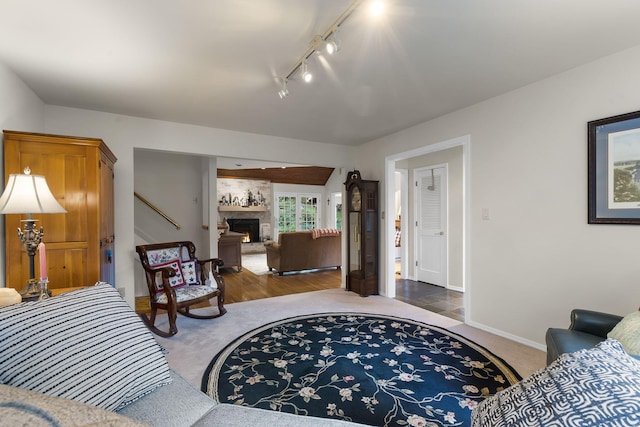 living area with a large fireplace, carpet, and baseboards