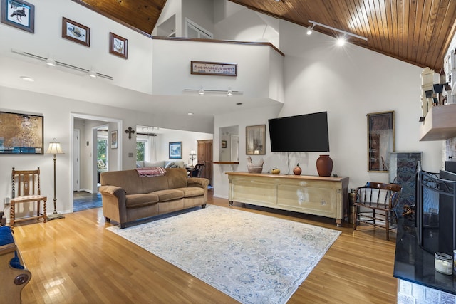 living room featuring rail lighting, wood ceiling, high vaulted ceiling, and light wood-style flooring