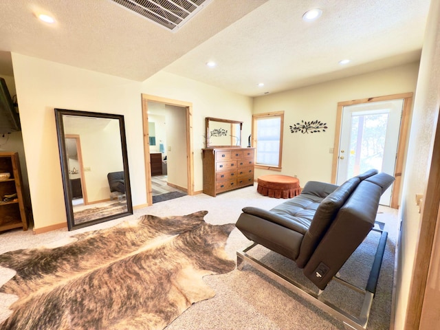 carpeted living room featuring recessed lighting, visible vents, a textured ceiling, and baseboards