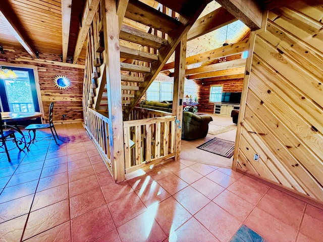 corridor featuring wooden ceiling, wooden walls, beam ceiling, and tile patterned floors