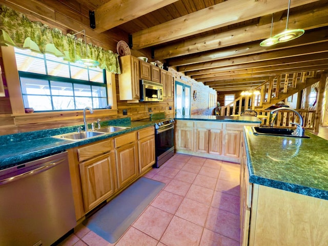 kitchen with light tile patterned floors, stainless steel appliances, a sink, and pendant lighting