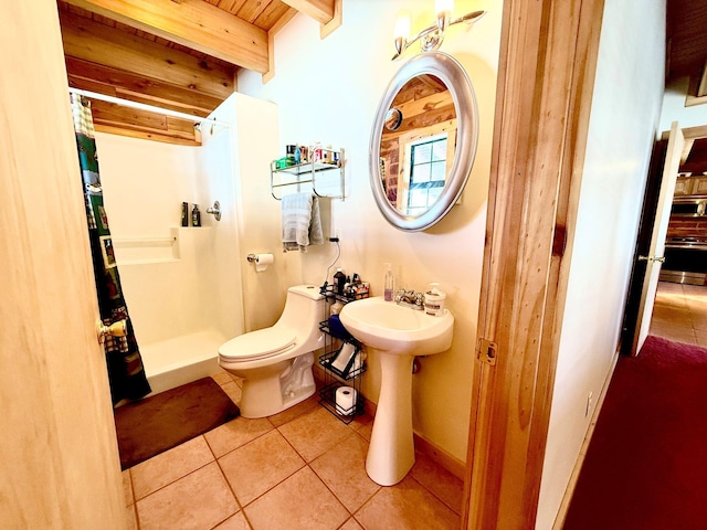 full bathroom featuring a stall shower, baseboards, toilet, tile patterned flooring, and beam ceiling