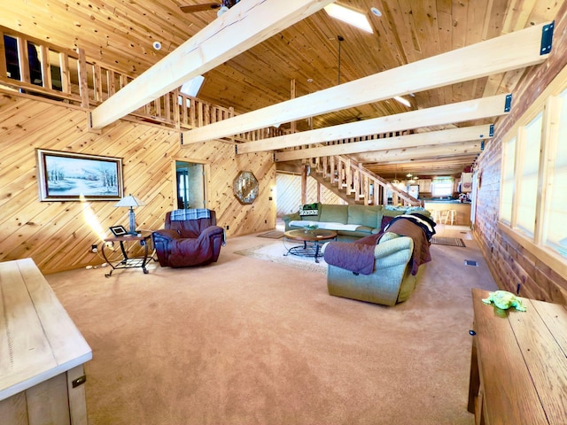 interior space featuring wood walls, stairway, and beam ceiling