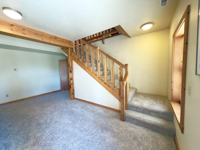 interior space featuring carpet, beam ceiling, visible vents, and baseboards