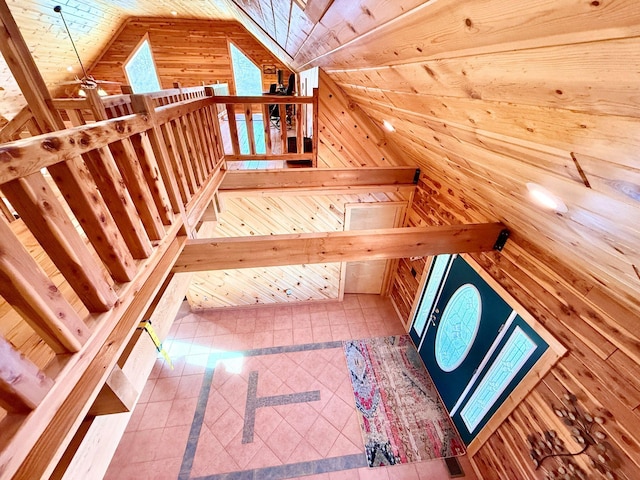 interior space with vaulted ceiling, wood walls, and tile patterned flooring