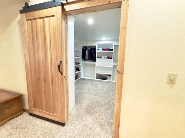 interior space with light carpet and a barn door