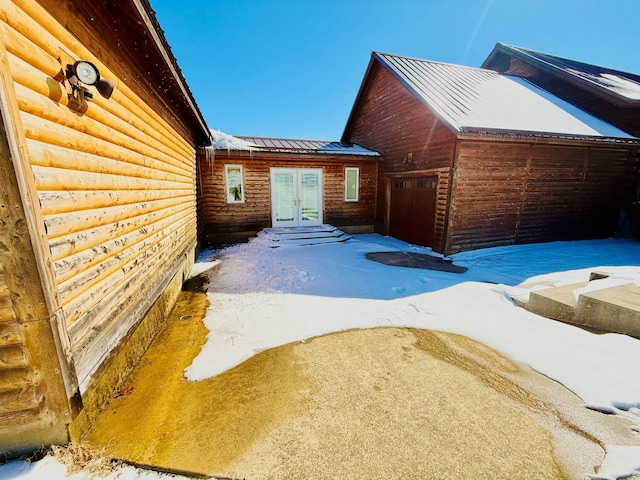 view of home's exterior with a garage, french doors, and metal roof