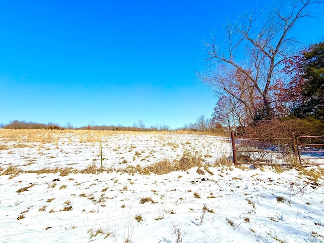 snowy yard featuring a rural view