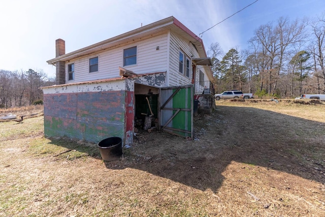 back of house featuring a chimney