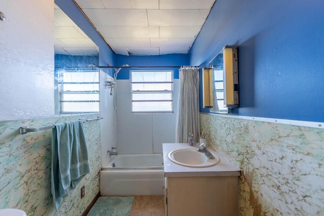 full bath with toilet, vanity, tile walls, wainscoting, and shower / bath combo with shower curtain