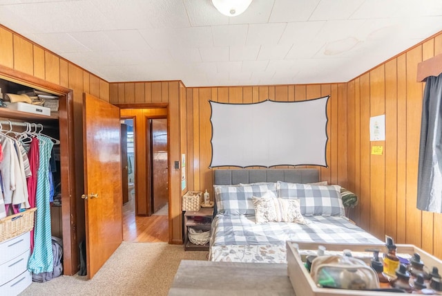 bedroom featuring wood walls and light colored carpet