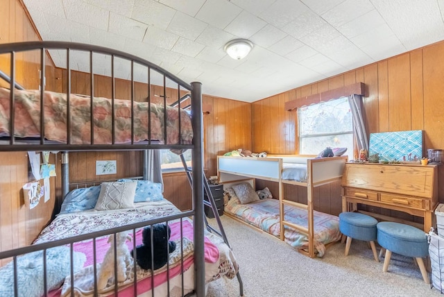 bedroom with wood walls and carpet flooring