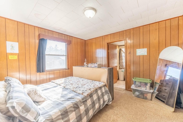 bedroom featuring light carpet and wood walls