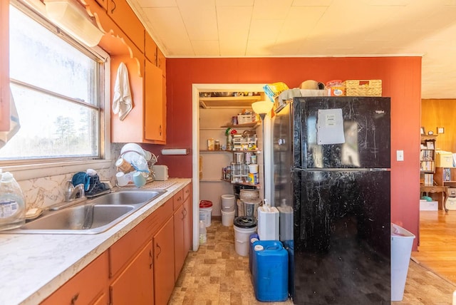 kitchen with brown cabinets, light countertops, a sink, and open shelves