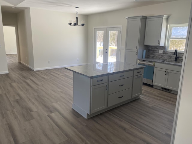 kitchen featuring dishwasher, gray cabinets, a sink, and a center island