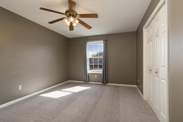 spare room featuring carpet floors, baseboards, and a ceiling fan