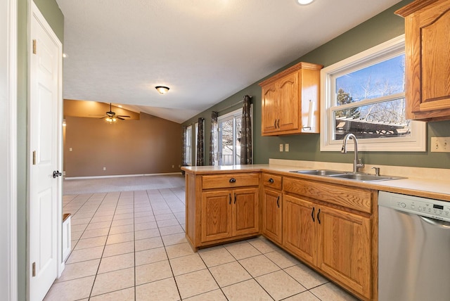 kitchen with light tile patterned floors, stainless steel dishwasher, vaulted ceiling, a sink, and a peninsula