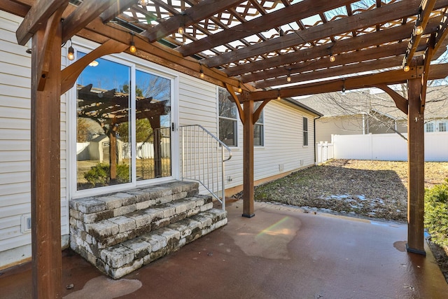 view of patio / terrace featuring an outbuilding, fence, and a pergola