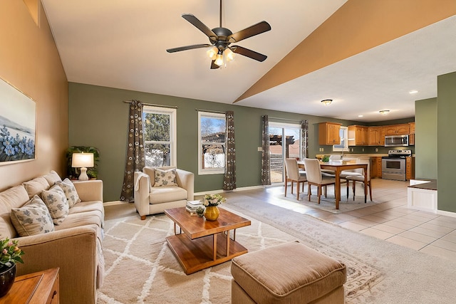 living area featuring light tile patterned floors, ceiling fan, vaulted ceiling, and baseboards