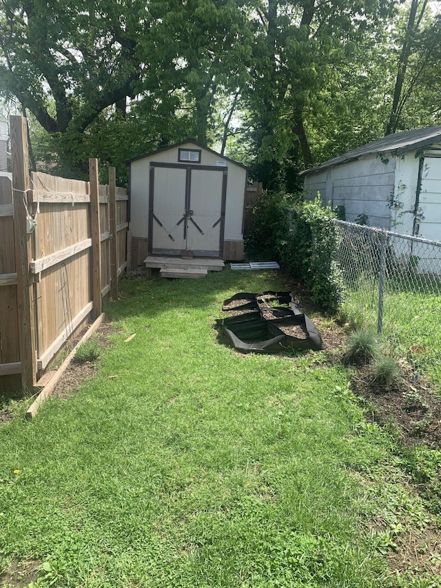 view of yard featuring an outbuilding, a fenced backyard, and a storage shed