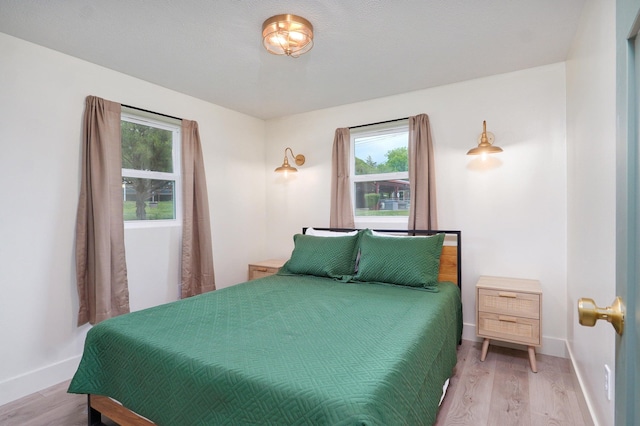 bedroom with light wood-style flooring and baseboards