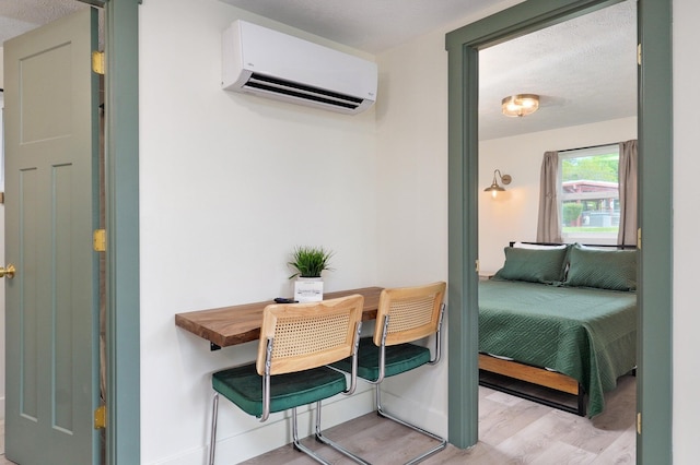 interior space with an AC wall unit and light wood finished floors