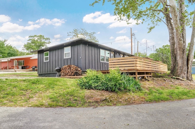 view of property exterior with board and batten siding and a wooden deck