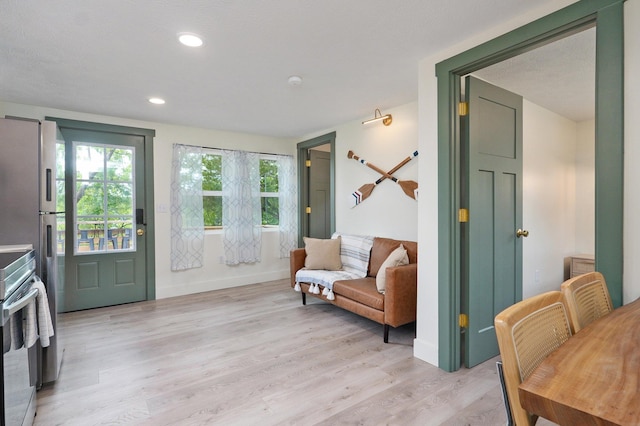 living area featuring recessed lighting, light wood-style flooring, and baseboards