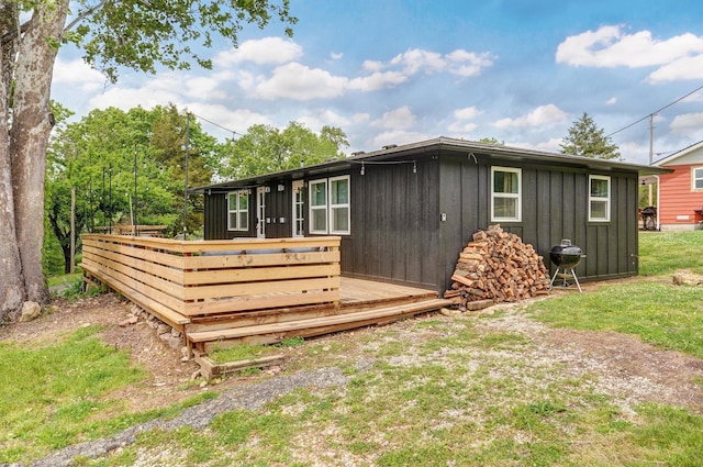 back of house with board and batten siding and a wooden deck