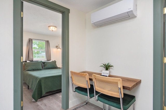 bedroom featuring an AC wall unit and wood finished floors