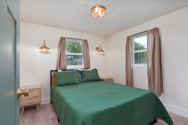 bedroom featuring light wood-style floors and baseboards