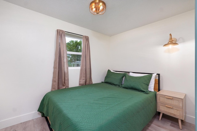 bedroom featuring light wood-style flooring and baseboards