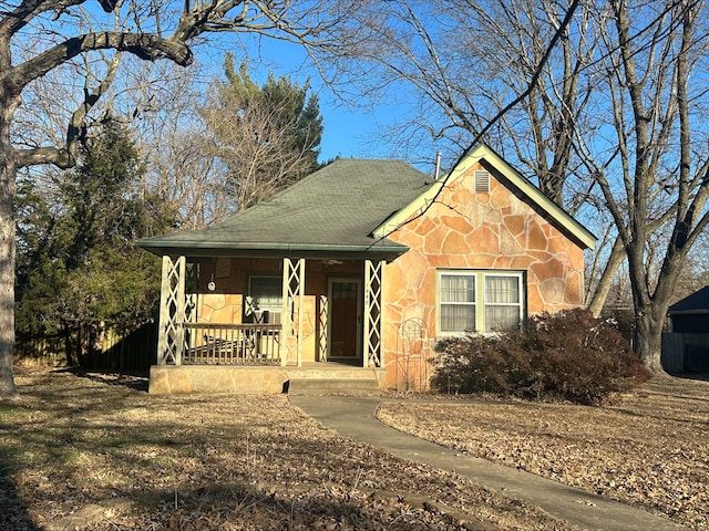 view of front of house with stone siding and a porch