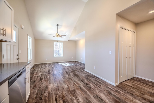 unfurnished living room featuring a ceiling fan, dark wood finished floors, high vaulted ceiling, and baseboards