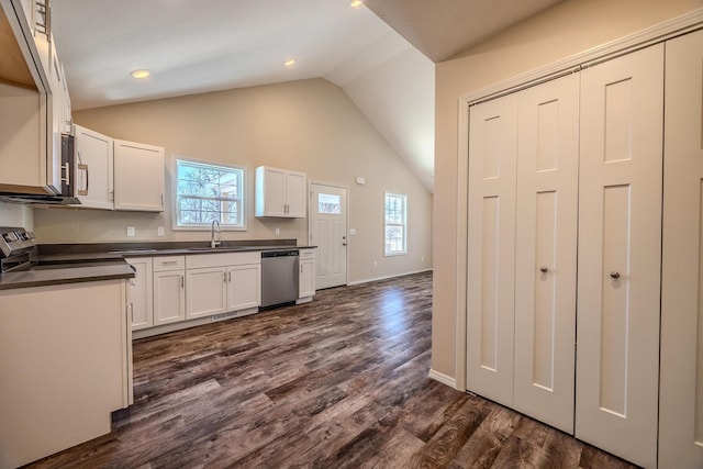 kitchen featuring dark countertops, appliances with stainless steel finishes, white cabinets, and a sink