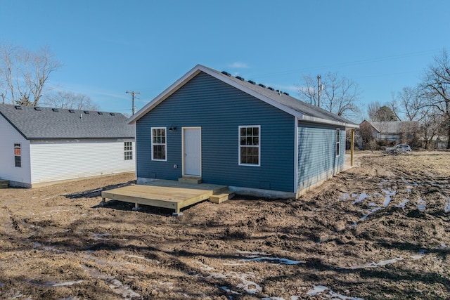 rear view of property featuring a wooden deck