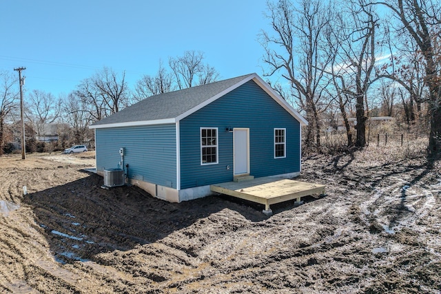 view of property exterior featuring a shingled roof, a wooden deck, and central air condition unit