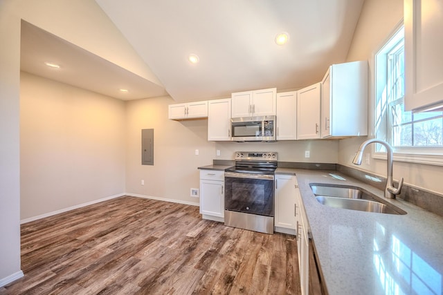 kitchen featuring appliances with stainless steel finishes, white cabinets, and a sink