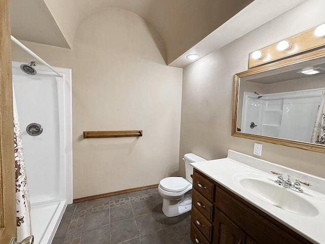 bathroom with toilet, a shower, vanity, and baseboards