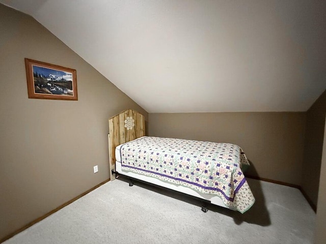 bedroom with carpet floors, lofted ceiling, and baseboards