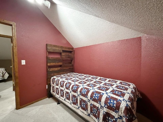 bedroom featuring a textured ceiling, vaulted ceiling, carpet flooring, and a textured wall