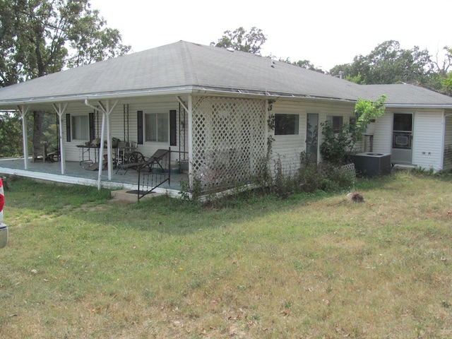 exterior space featuring a patio area, a front lawn, and central AC unit