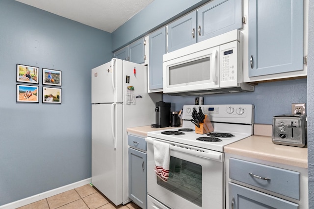 187 Clubhouse Dr Unit 19, Branson, MO 65616 - kitchen with white appliances, light countertops, baseboards, and light tile patterned floors