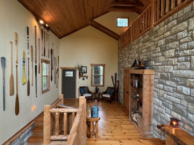 foyer entrance with high vaulted ceiling, light wood-style flooring, and wood ceiling