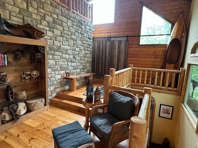 living area featuring a towering ceiling, hardwood / wood-style floors, and a barn door