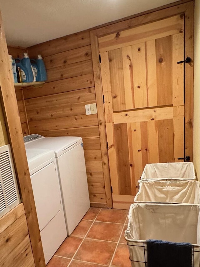 washroom featuring wood walls, washer and dryer, and tile patterned floors