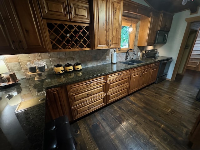 kitchen featuring black electric range, decorative backsplash, dark wood-style flooring, and a sink