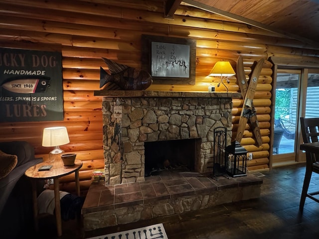 sitting room with log walls, vaulted ceiling, a stone fireplace, and hardwood / wood-style flooring