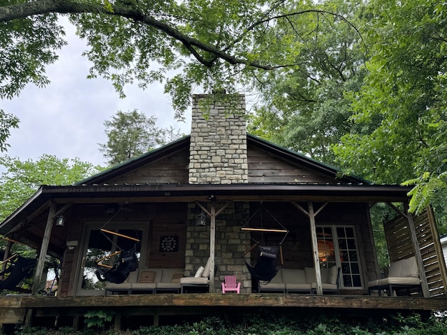 back of house featuring a chimney