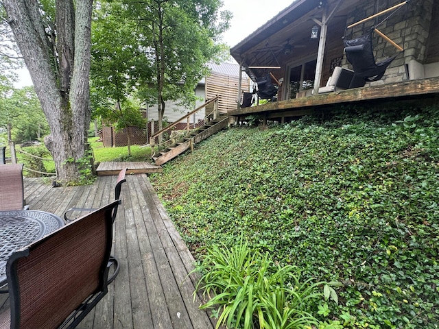 exterior space with stairway, a deck, and a ceiling fan